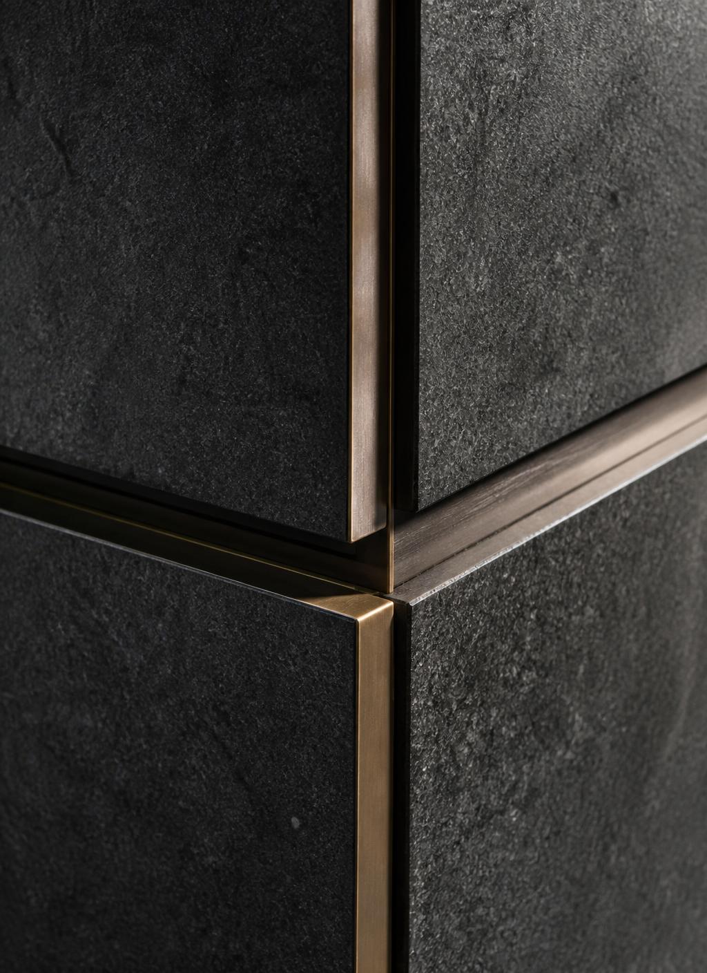 Detail of honed granite meeting a bronze reveal